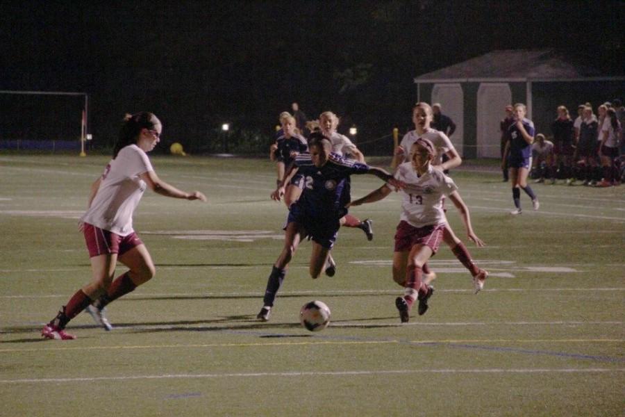 Gabby Thomas 15 pushing through Worcester defense, heading for goal. 
