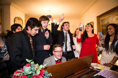 Mr. Joshua Harper plays piano as students sing holiday songs during dessert at the Hills' house.