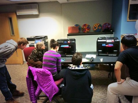 Michelle Lawson and students watch the 3D printer work its magic.