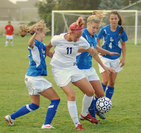 Young girls playing a game of soccer.