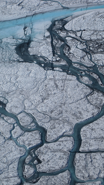 A stream of meltwater cuts trough a glacier in Greenland. Credit: Flickr.