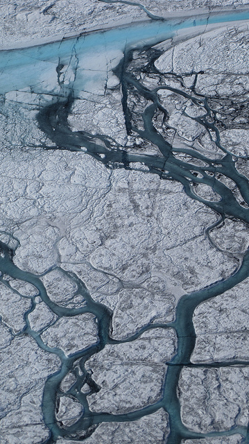 A+stream+of+meltwater+cuts+trough+a+glacier+in+Greenland.+Credit%3A+Flickr.